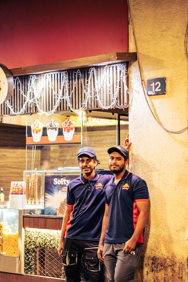 Two friendly and professional on-site electricians posing and smiling in their uniform polos.